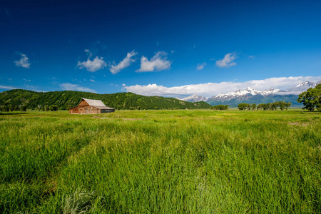 古老的摩门谷仓在大提顿山脉，低云。 美国怀俄明州大提顿国家公园。