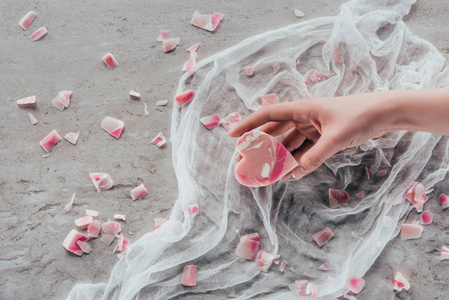 大理石表面白色纱布上带有粉红色心形肥皂的女性手