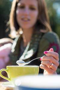 年轻女子与清漆指甲勺子泡沫咖啡