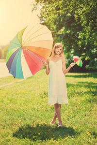 微笑的女人在户外选择大或小彩虹伞