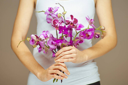 女人手里拿着一些紫兰花，感官工作室的镜头可以作为背景