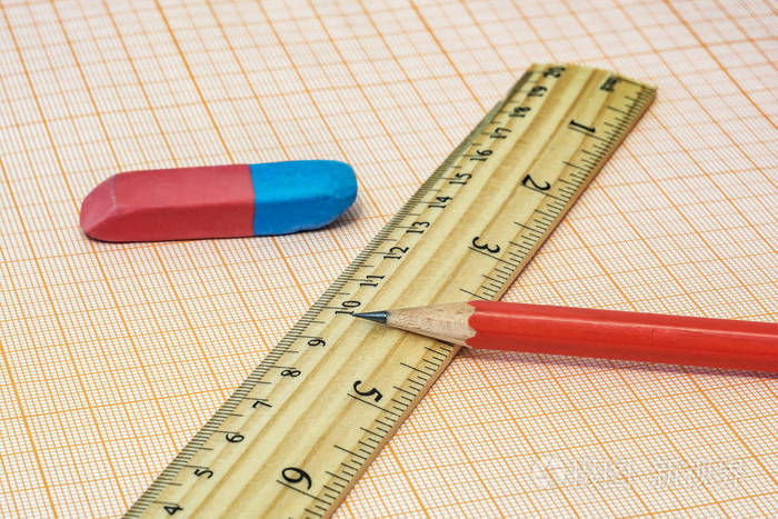 在毫米纸上躺着一把尺子一块橡皮和一个简单的penc