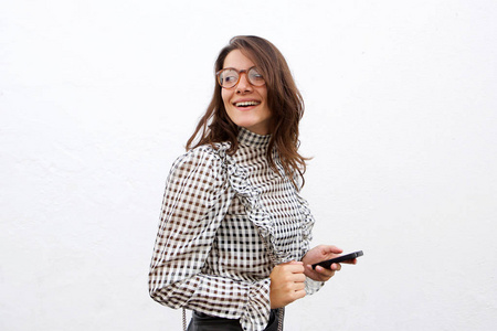 带着手机和眼镜走在白色背景上的微笑时髦女人的肖像。