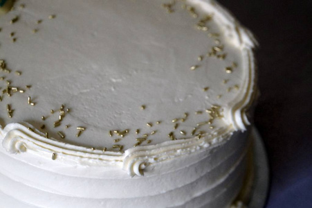 用金色的花洒装饰在白色蛋糕上图片