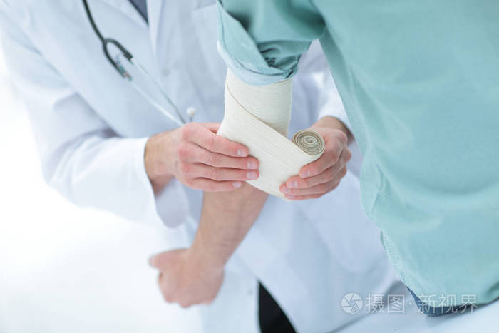 医生用弹力绷带包扎病人的肘关节