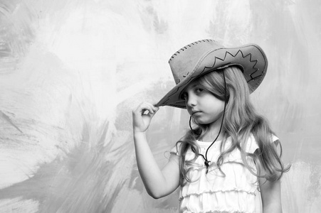 小女孩在牛仔帽上多彩的背景下，复制空间