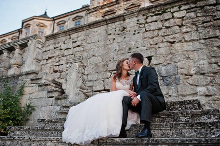 浪漫的新婚夫妇坐在楼梯旁的城堡