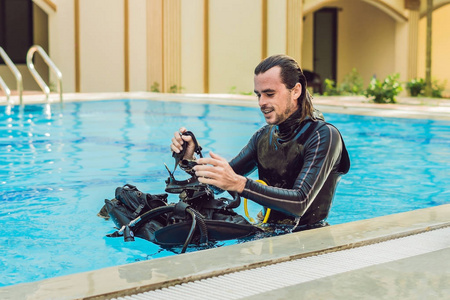 一位快乐的潜水教练的肖像,准备在游泳池里教潜水.照片