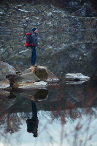 游客在平静的湖面上矗立在花岗岩石上