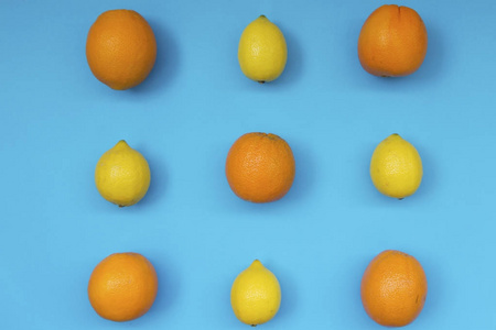 蓝色背景下新鲜橙子和柠檬的彩色水果图案的顶部视图