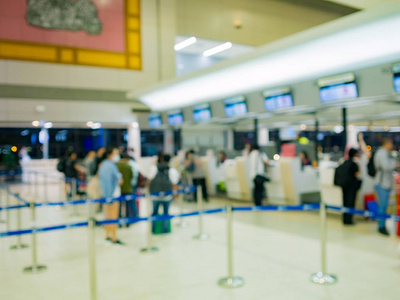 旅客和游客在候机楼的航空柜台排队办理登机手续