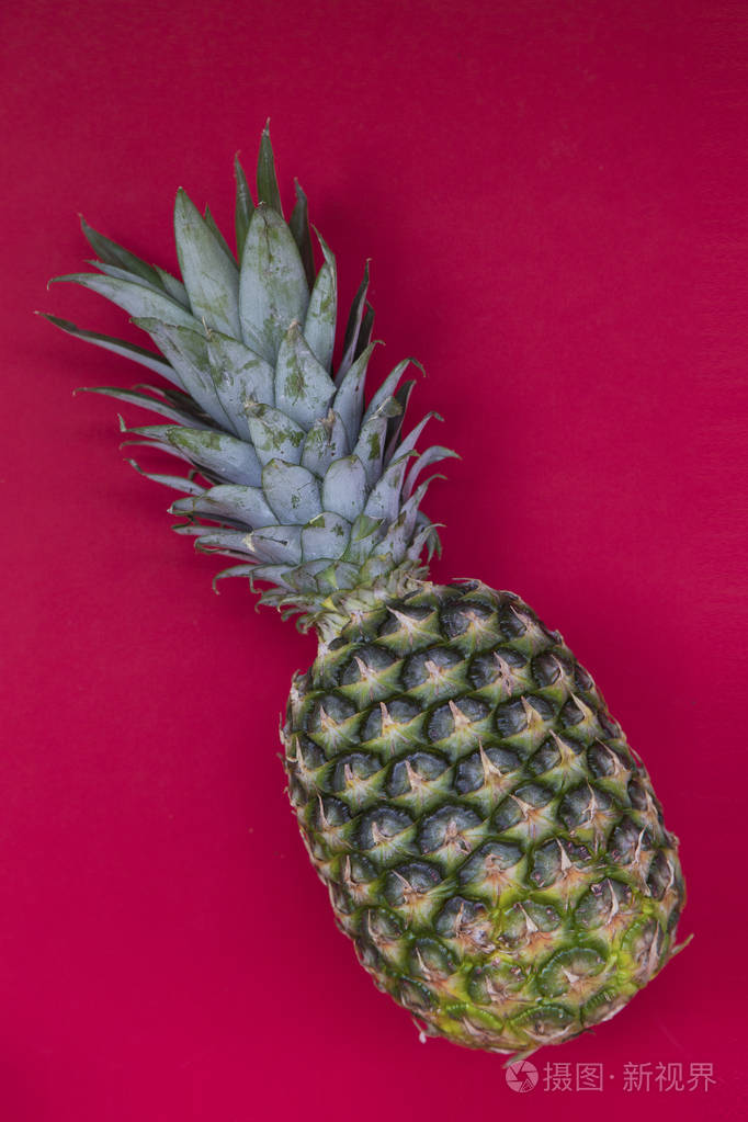 红色背景下新鲜菠萝彩色水果图案的顶部视图