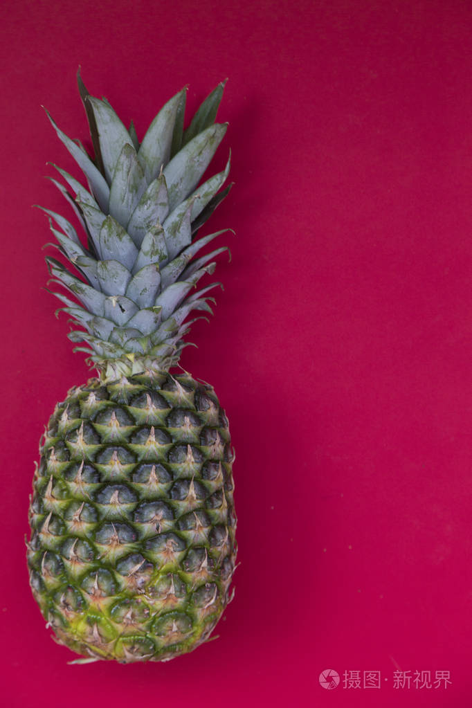 红色背景下新鲜菠萝彩色水果图案的顶部视图