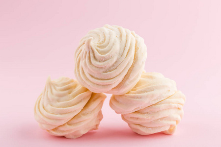 自制白色的西风或棉花糖在粉红色的背景