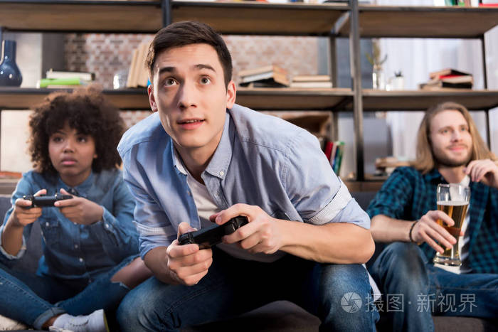 多文化的朋友在家里沙发上玩电子游戏照片-正版商用图片1108j8-摄图新