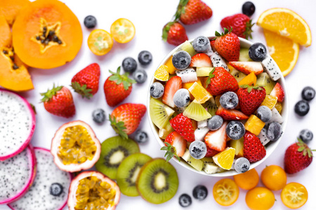 白色背景下的一碗健康的新鲜水果沙拉。 混合新鲜水果草莓橙蓝莓猕猴桃。 从上面看。