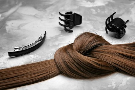 s set and strand of brown hair on grey background