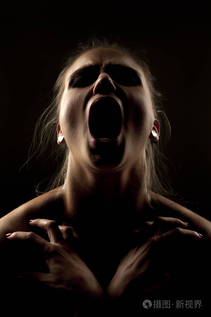 影子里的女人在黑暗的背景上尖叫