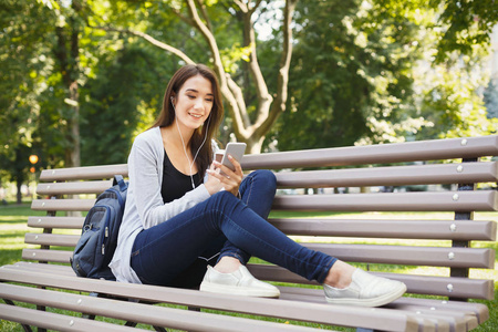 学生坐在公园和使用智能手机
