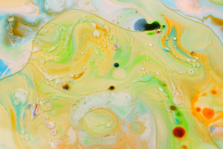 五颜六色的油滴在液体抽象的彩色背景流行艺术纹理黄色圆圈与明亮的滴油漆极简主义粘贴图案。