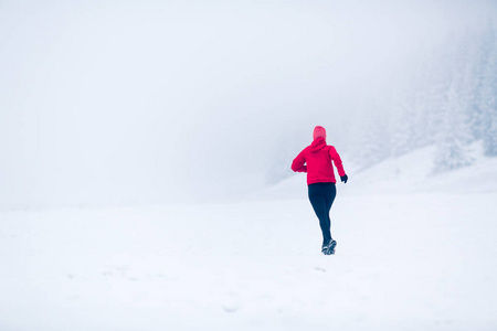 冬天山上的女人在雪地上奔跑图片