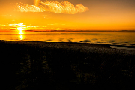 日落海滩阳光在天空的橙色和海上轮廓波兰