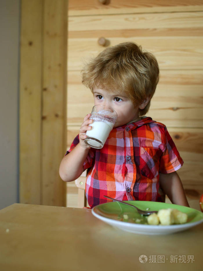 孩子或金发碧眼的快乐男孩在餐桌上吃饭