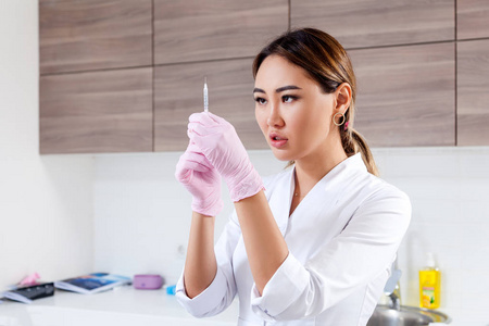 年轻女子阿兹台克医生美容师穿着白色实验衣和无菌手套准备注射肉毒杆菌毒素