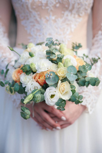 新娘穿着白色连衣裙，手里捧着各种颜色的美丽花束