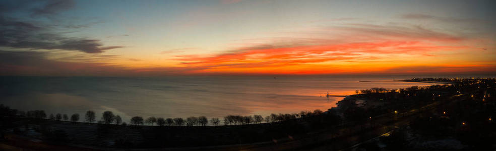 美丽的风景照片，生动的红色橙色和黄色日出在芝加哥密歇根湖的水上