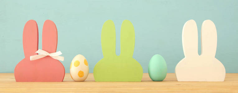 可爱的五颜六色的木兔耳朵和复活节彩蛋在木桌上