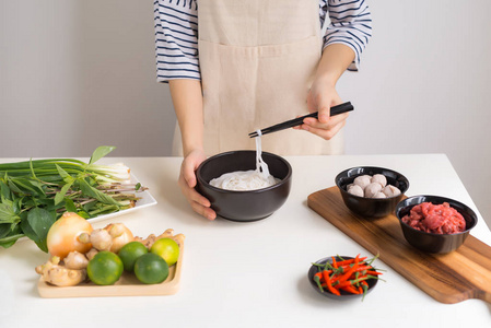 女厨师用香草肉米粉煮越南传统汤。