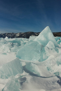 黎明在蓝色的腐殖质的冰湖贝加尔湖在一个下雪的田野在冬天的旅程。