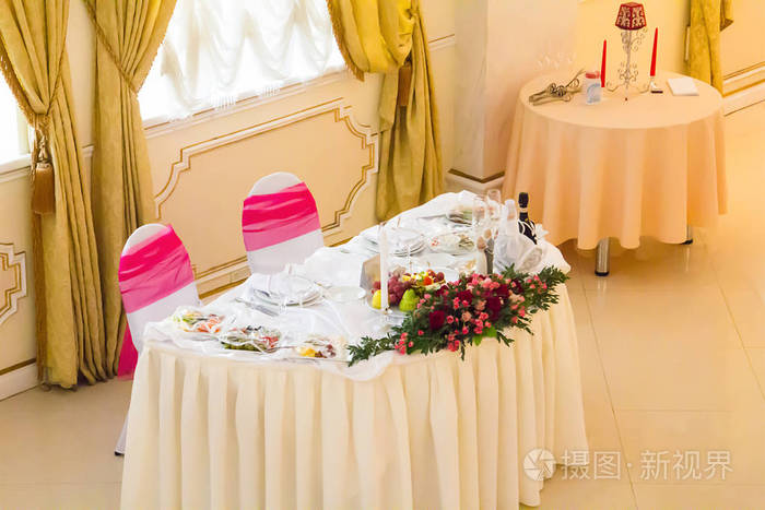 婚礼桌白色桌布鲜花喜庆摆在明亮的大厅照片-正版商用图片111yt0-摄图