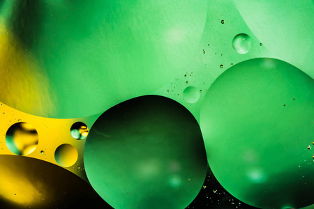 水和油, 美丽的颜色抽象背景基于绿色和黄色的圆圈和椭圆形, 宏观抽象