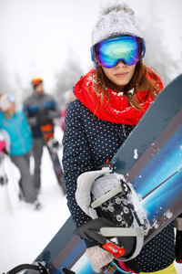 滑雪场上持有滑雪板的妇女