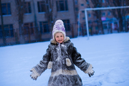 冬天的公园里有一个白雪皑皑的可爱小女孩