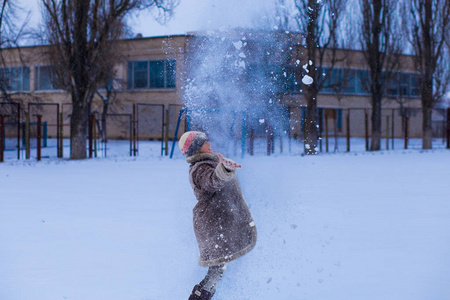 冬天的公园里有一个白雪皑皑的可爱小女孩