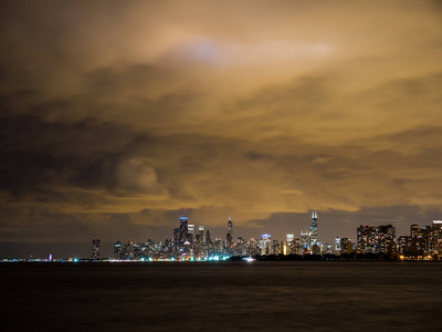 美丽的夜晚，长时间的曝光照片，五颜六色的灯光在芝加哥城市天际线与密歇根湖的前景和多云的天空，就在日落后。