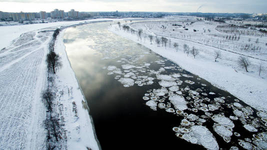 冰在河里游泳。 冬季景观从城市附近的上方拍摄。 上面的风景。 性质和抽象背景。