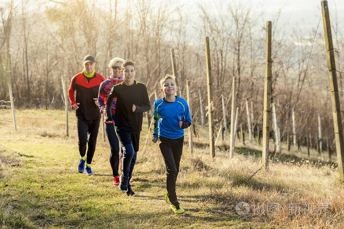 有两个男孩跑步或慢跑的快乐家庭