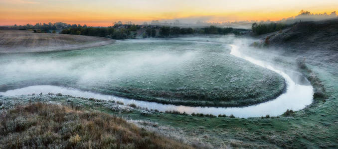 秋天的早晨。雾蒙蒙的黎明靠近风景如画的河流