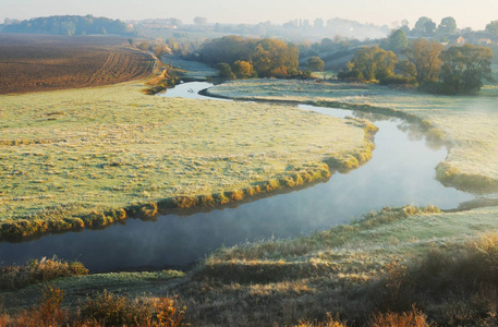 秋天的早晨。 雾蒙蒙的黎明靠近风景如画的河流
