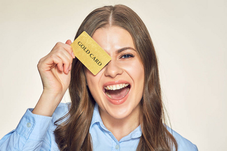 喜笑颜开的女人拿着信用卡对着米色背景