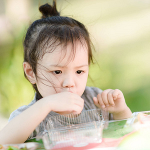 亚洲女孩 eationg 香肠在公园室外