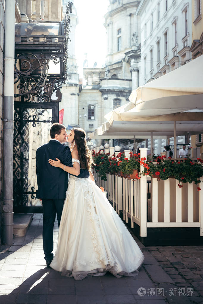 结婚夫妇在他们的步行沿着城市的老阳光街道照片-正版商用图片112k36