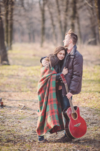 情侣漫步在一个浪漫的气氛与吉他户外在公园