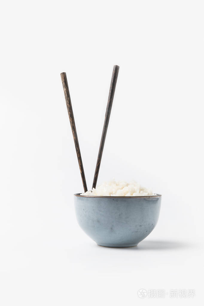 碗刚煮好的米饭用筷子夹在白色的表面