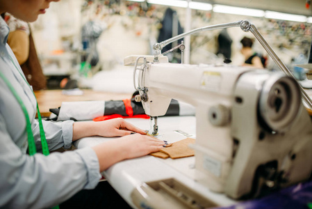 缝纫机上的女针线。 制衣厂的裁缝或裁缝