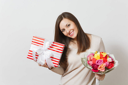 年轻漂亮的女人捧着花束美丽的玫瑰花, 礼物盒上有白色的背景。广告的复制空间。St. 情人节或国际妇女节概念